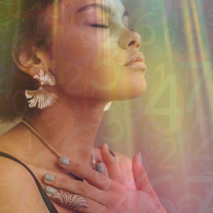 A woman meditating with closed eyes, surrounded by colorful numbers and spiritual symbols.